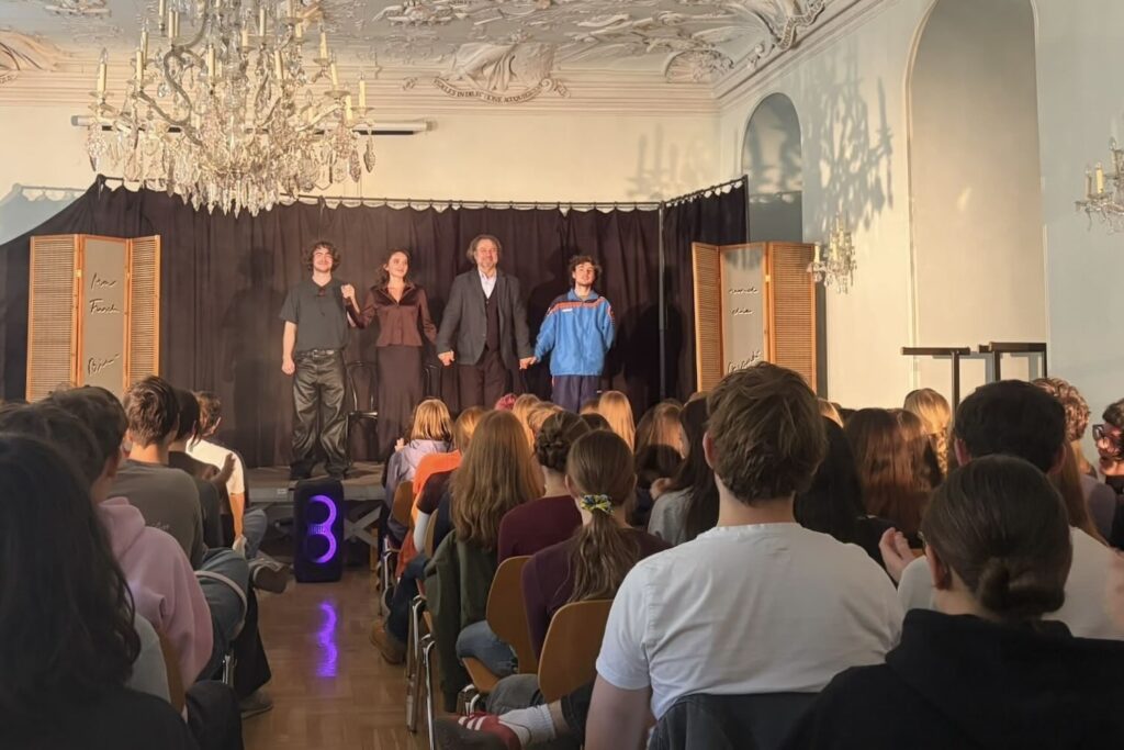 Vier Schauspieler halten sich an den Händen, nachdem sie im Festsaal des Gymnasiums St. Pölten aufgetreten sind.